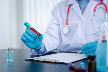 Doctors holding tubes of infected blood samples taking notes and analyzing for vaccines against infection in blood results, the concept of finding a vaccine against coronavirus19.