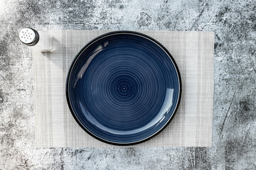 Round empty plate dark blue Placed on the table concrete black and White texture background and a...