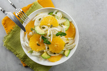 Oranges, fennel and avocado salad.  On green and orange napkins. Grey background. Top view. Copy space. - obrazy, fototapety, plakaty