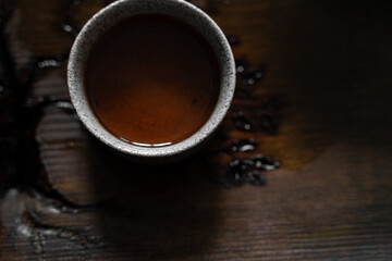 Traditional Chinese tea ceremony. A cup of puer tea surrounded by lights. 