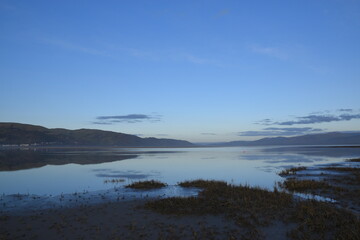 a view of the welsh mountains from ynyslas beach reflected in the estuary