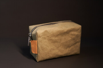 Zero waste paper made travel cosmetic bag on a black background. Make-up concept