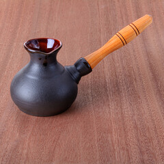 clay coffee pot on a wooden table, front view