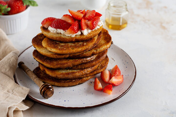 Stack of french toast with cottage cheese, honey and strawberries for breakfast. Selective focus