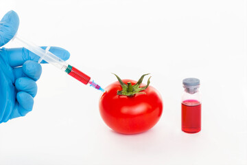 Tomato, ampoule and syringe with nitrates isolated on a white background. Pesticides and nitrates...