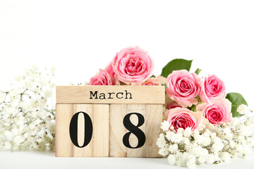 Wooden calendar with bouquet of flowers on white background