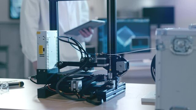 Scientific Assistant working with 3D printer in laboratory