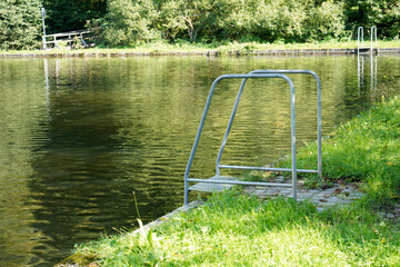 Natural swimming pool in the forest in Bavaria in summer photographed in sunlight