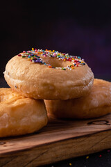 glazed donuts on wooden base with dark background