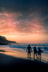Surf group of people walk to the ocean waves to enjoy surf water sport activity in the sunset -...