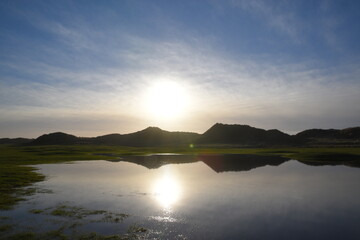 the sand dunes of ynyslas wales reflected in the flooded waters  next to the road 