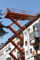 Fototapeta na wymiar Cosmetic and major repairs of facades of multi-storey municipal housing. Construction cradle lift.