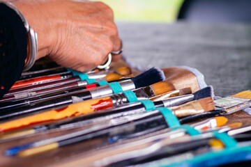 closeup of artist brushes with different sizes and shapes with nature background