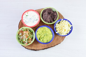 Sauces and dressings for Mexican food in bowls on white wooden background