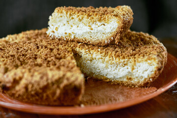 A piece of orange cake with mint on plate, closeup.