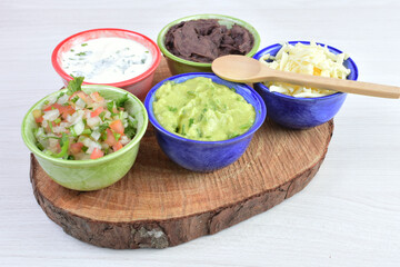 Sauces and dressings for Mexican food in bowls on white wooden background
