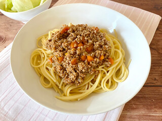 Spaghetti pasta with Bolognese sauce. Noodles with minced meat ragù and iceberg salad.