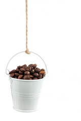 A full bucket of coffee beans hanging from a rope.