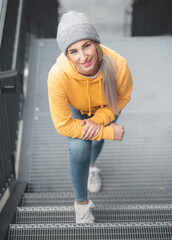 Above view of smiling full length beautiful young woman standing. Outdoors daylight. Pretty smile girl wearing casual clothing.