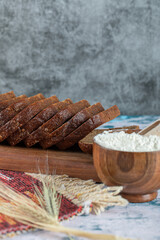 Slices of brown bread with wheat on a wooden board