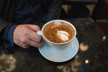 カフェで男性がコーヒーを飲むシーン