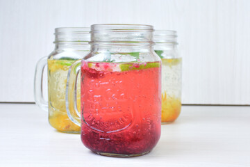 Fototapeta na wymiar Colorful drinks, Italian sodas with ice, fruit flavors on white wooden background