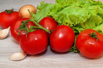 Red tomatoes and lettuce on the table. Vegetarian healthy food