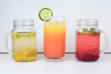 Colorful drinks, Italian sodas with ice, fruit flavors on white wooden background