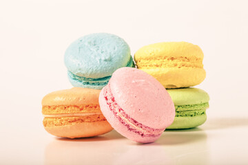 Colorful cake macaroons on a light background. Toned