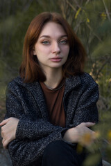Portrait of a girl on a background of autumn nature. Portrait of a woman in warm colors.