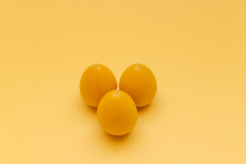 Yellow candle from beeswax in the form of egg for celebrating Easter.