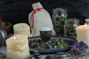 Fototapeta na wymiar Magic altar with mystical herbs, salt, candles and crystals. Witch sanctuary sacred esoteric concept.