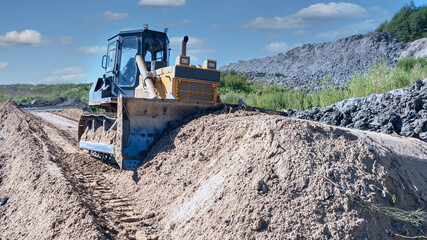 the process of leveling sand with a modern bulldozer during the construction of a dirt road