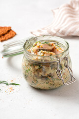 Pickled herring in a glass jar. Senapssill. Pickled herring with mustard, vinegar, onion, oil,...