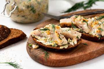 Sandwich with rye bread and pickled herring. Pickled herring with mustard, vinegar, onion, oil, dill, and sour cream. Scandinavian cuisine. Senapssill