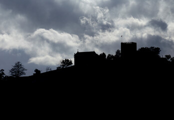 Obraz premium Lanhoso Castle silhouette against the sunlight with a blue and cloudy sky in Povoa de Lanhoso, Portugal.