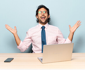 young handsome indian man feeling happy, excited, surprised or shocked, smiling and astonished at...