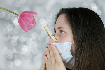 young woman, a girl in a white medical mask with long blond hair, her nose is clamped with a wooden...
