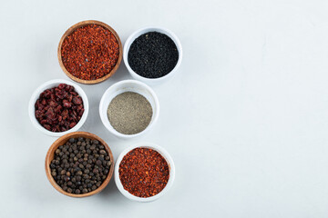Many bowls of spices on a white background