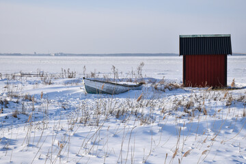 Old rowing boat by a red fishing cabin