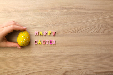 woman's hand with a painted egg on the table