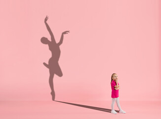 Childhood and dream about big and famous future. Conceptual image with girl and drawned shadow of...