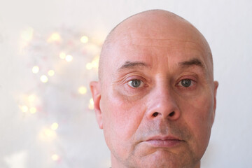 face of an elderly bald man close-up, senor looks, turns his head, thinks, dreams of a good,...