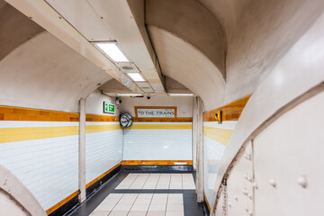 London, UK tube station underground corridor hallway with nobody and sign direction for to the...