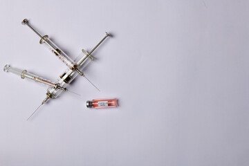 medical syringes and covid vaccine on white background