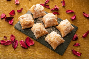Cakes with icing sugar on black slate plate