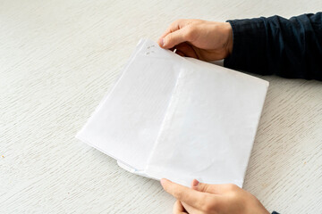 hands holding the paper with text and put it in the convert to send the letter