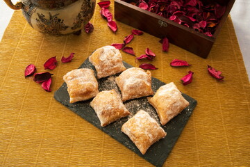 Cakes with icing sugar on black slate plate