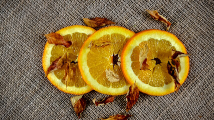 Plasterki pomarańczy i suche jesienne liście.