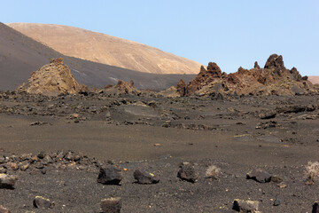 Disperse rocks in volcanic landscape at Timanfaya natural park in Lanzarote, Canary Islands....